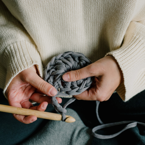Person holding crochet work and hook