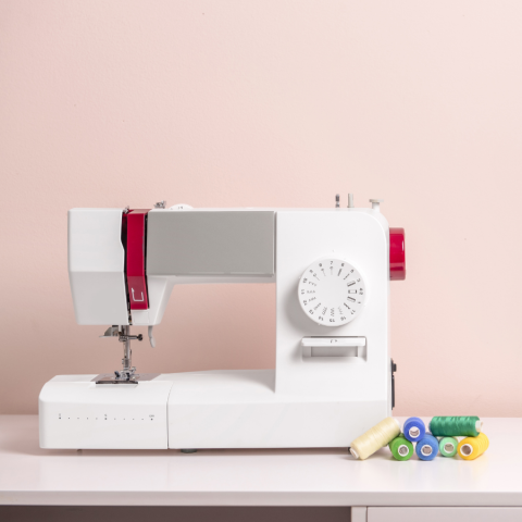 White sewing machine against pink background